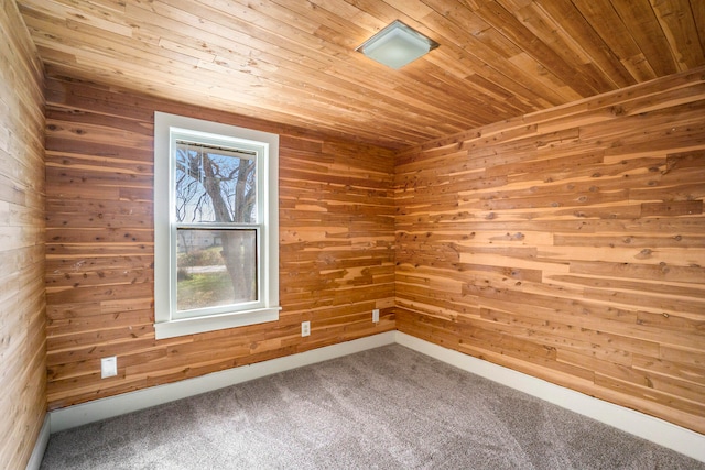 carpeted spare room featuring wooden ceiling and wooden walls