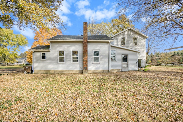 rear view of property featuring a lawn