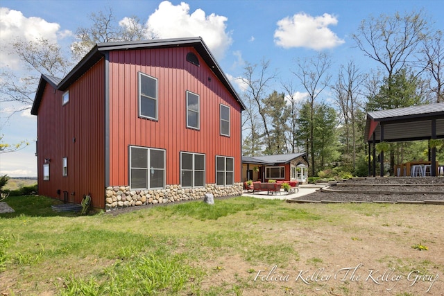 back of house with a yard and a patio