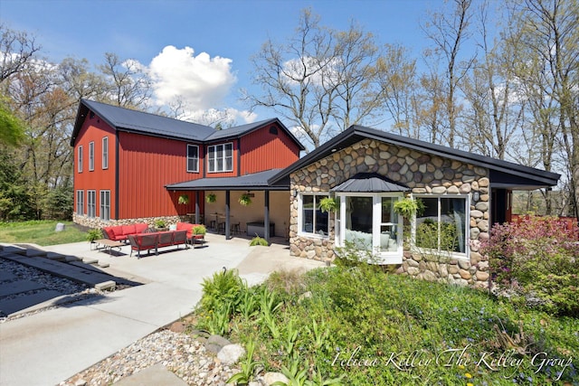 back of property with outdoor lounge area and a patio area