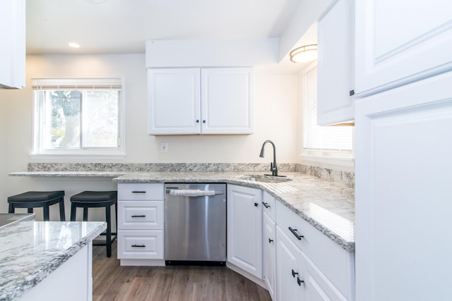 kitchen featuring white cabinets, light stone counters, light hardwood / wood-style flooring, dishwasher, and sink