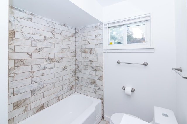 bathroom featuring toilet and tiled shower / bath