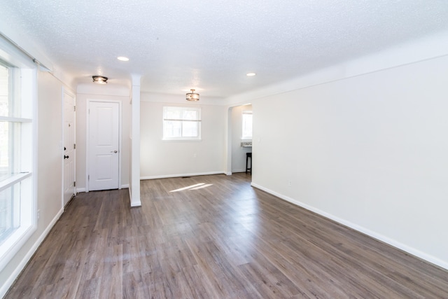 interior space with a textured ceiling and hardwood / wood-style floors