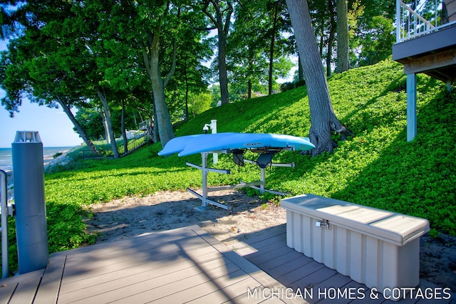 deck with a hot tub and a lawn