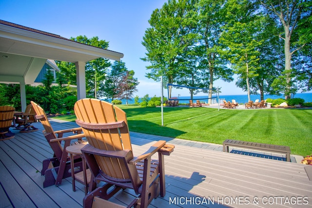 deck with a lawn and a water view