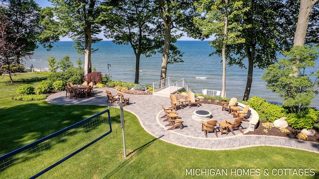 view of yard featuring an outdoor fire pit, a patio area, and a water view