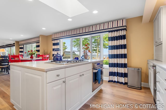 kitchen with white cabinetry, light hardwood / wood-style floors, and appliances with stainless steel finishes