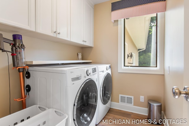 washroom featuring sink, hardwood / wood-style floors, independent washer and dryer, and cabinets