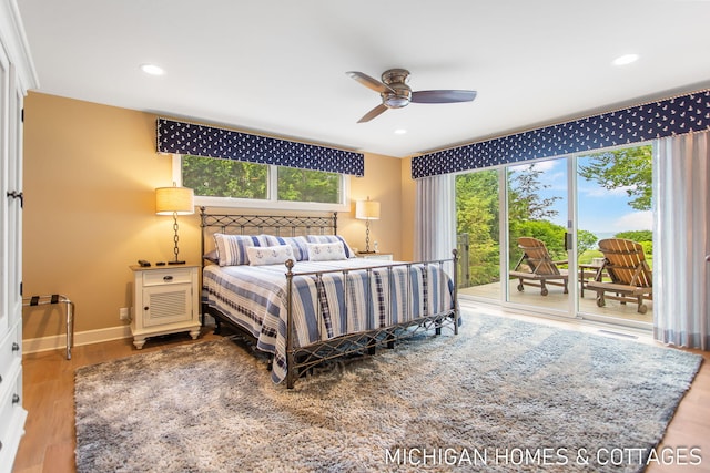 bedroom with access to outside, multiple windows, hardwood / wood-style flooring, and ceiling fan