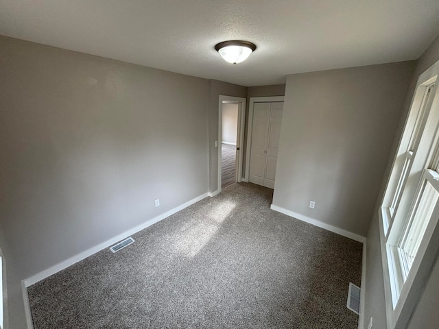 unfurnished bedroom featuring carpet and a textured ceiling