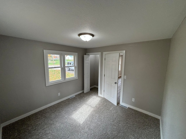 unfurnished bedroom with carpet flooring and a textured ceiling