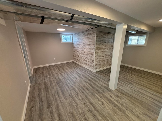 basement with plenty of natural light and dark hardwood / wood-style floors