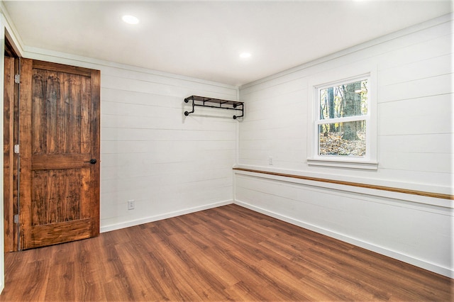 spare room featuring wood walls and wood-type flooring