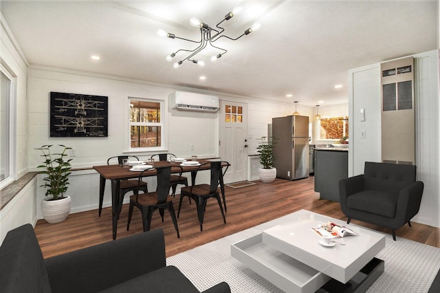 living room featuring ornamental molding, dark wood-type flooring, a wall mounted AC, and a notable chandelier