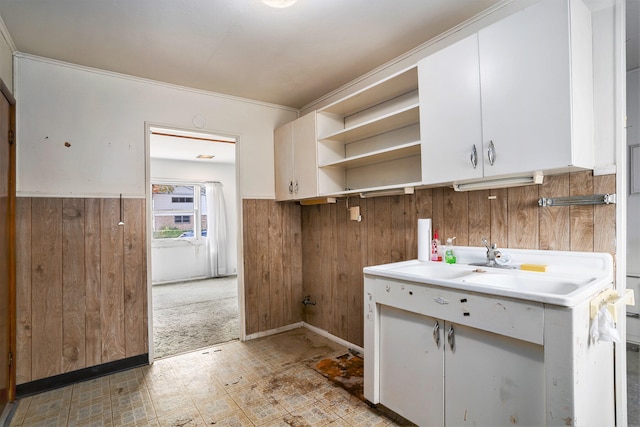 kitchen featuring wood walls and white cabinets