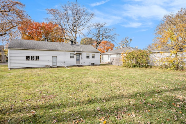 rear view of property featuring a lawn