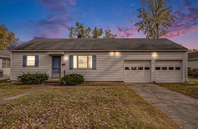 single story home with a garage and a lawn