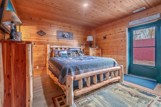 bedroom with wooden walls, hardwood / wood-style flooring, and wooden ceiling