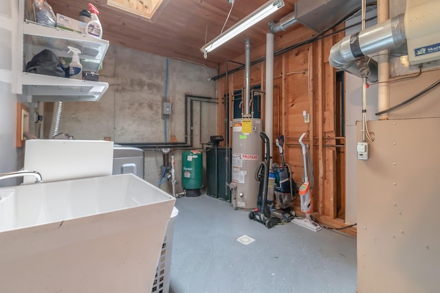 basement featuring heating unit, sink, and gas water heater