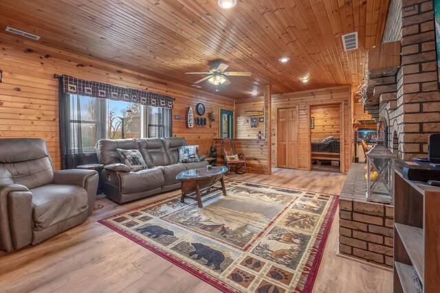 living room featuring wooden walls, wood-type flooring, wooden ceiling, and ceiling fan