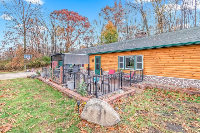 back of property featuring a yard and a wooden deck