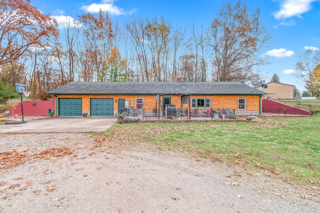 ranch-style home featuring a front lawn, a garage, and covered porch