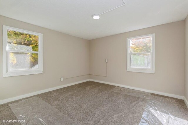 carpeted spare room featuring a healthy amount of sunlight