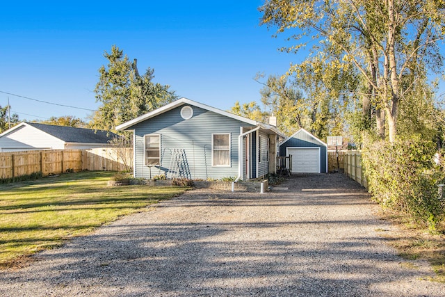 view of front of house with a front yard, an outbuilding, and a garage