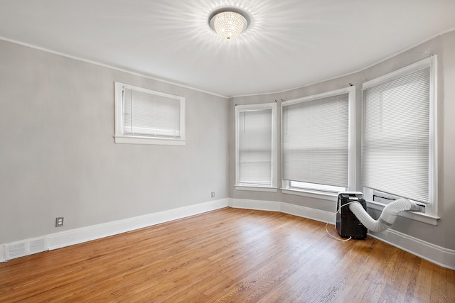 spare room with light hardwood / wood-style flooring and crown molding