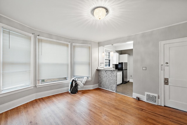 unfurnished room featuring ornamental molding and wood-type flooring