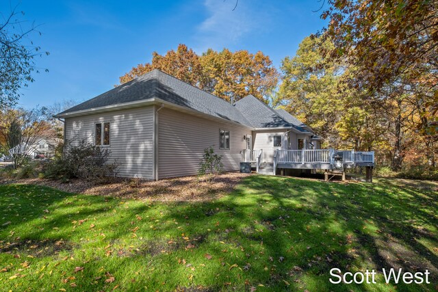 back of house featuring a wooden deck and a yard