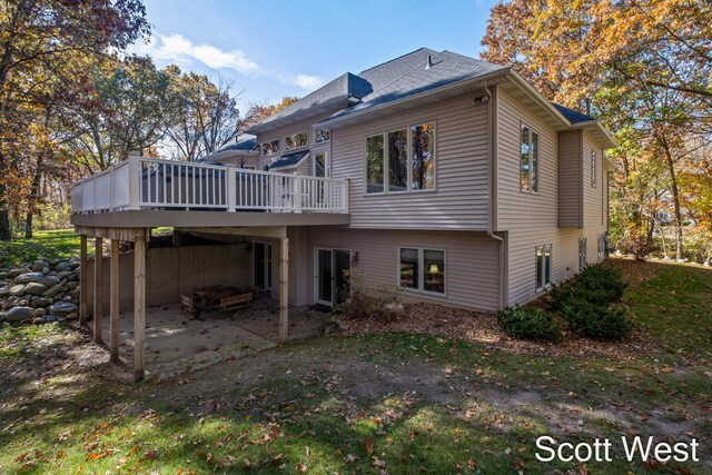 back of property featuring a wooden deck and a patio area