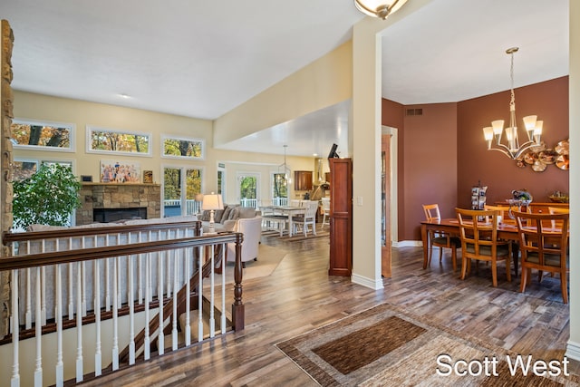 living room featuring hardwood / wood-style flooring, a fireplace, and a chandelier