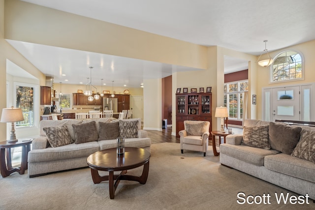 living room featuring light carpet and a chandelier