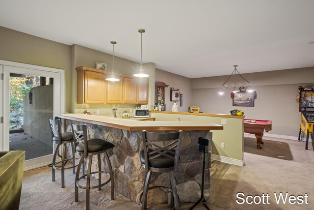 kitchen featuring billiards, light brown cabinetry, hanging light fixtures, a kitchen breakfast bar, and kitchen peninsula