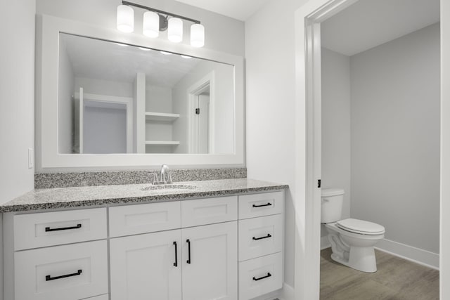 bathroom with vanity, hardwood / wood-style floors, and toilet