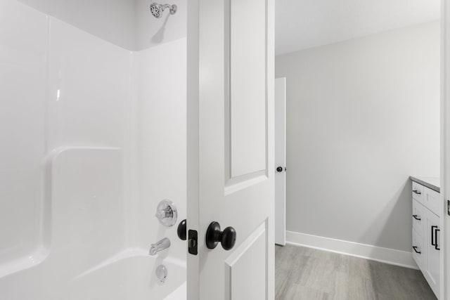 bathroom with vanity, shower / washtub combination, and hardwood / wood-style flooring