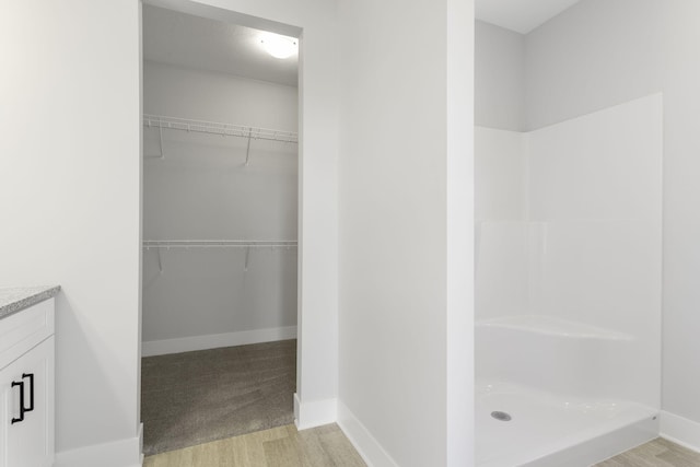 bathroom with vanity, a shower, and wood-type flooring