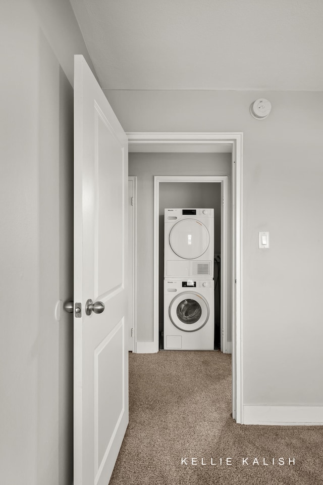 laundry room with carpet flooring and stacked washer and clothes dryer