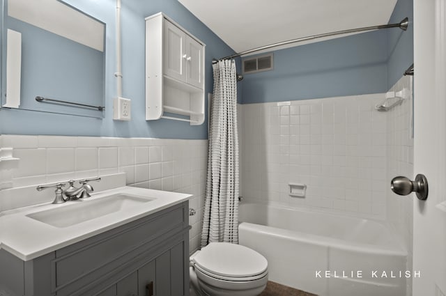 full bathroom with toilet, vanity, shower / bath combo, and tile walls