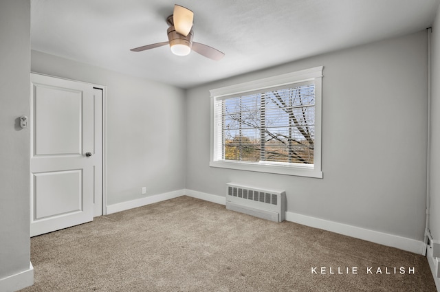 unfurnished room featuring ceiling fan, radiator, and light colored carpet