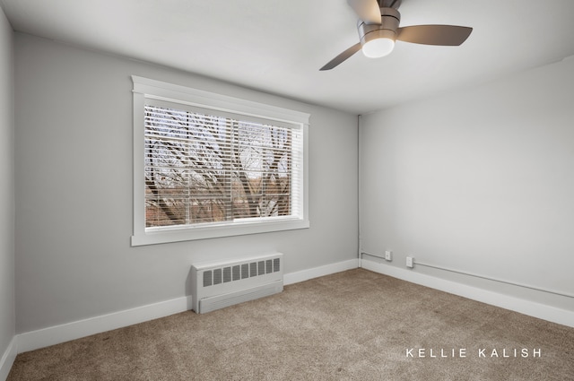 empty room with ceiling fan, light colored carpet, and radiator heating unit