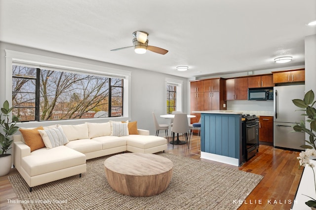 living room with hardwood / wood-style floors and ceiling fan