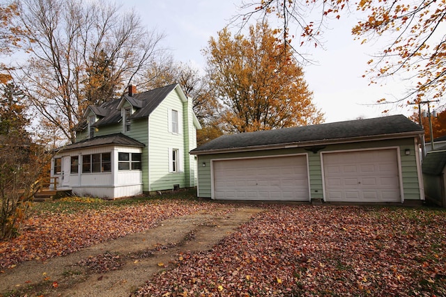 view of property exterior with a sunroom and a garage