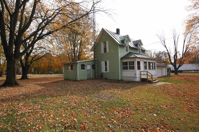 view of property exterior featuring a lawn and a sunroom