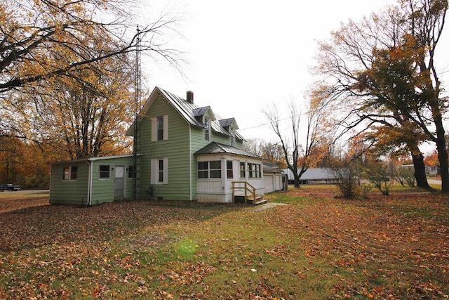 view of side of home featuring a yard and a sunroom