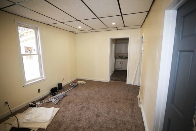 unfurnished room featuring a drop ceiling and carpet