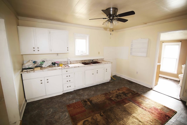 kitchen with sink, white cabinets, ceiling fan, and plenty of natural light