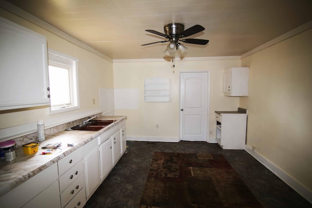 kitchen featuring ceiling fan, sink, and white cabinets