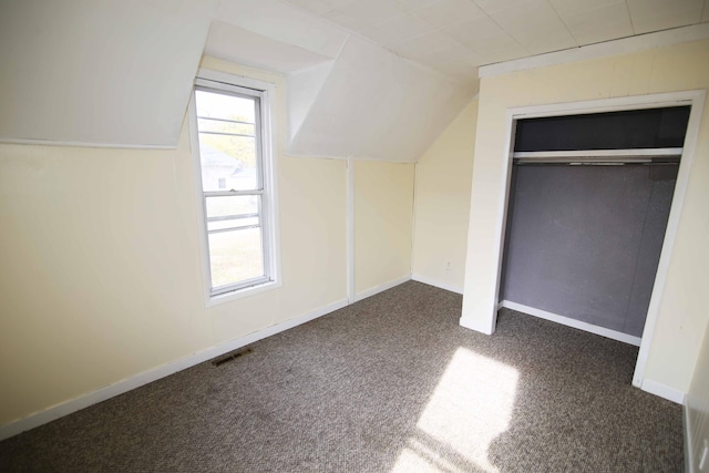 additional living space with vaulted ceiling and dark carpet